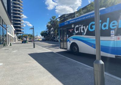 City Glider blue bus pulls up to bus stop at west end.
