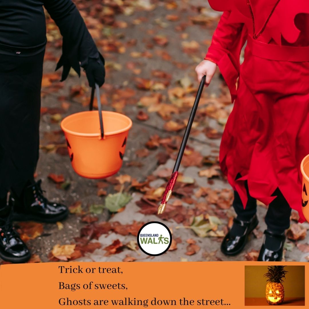 Two children with a bucket and a wand standing on an autumnal footpath ready for trick or treating!
