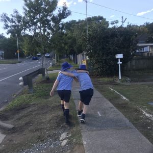 Kids walking home from school arm in arm